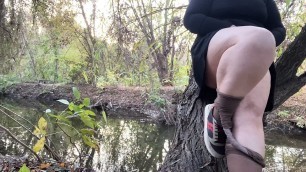 MILF in a short dress and pantyhose masturbates on the river bank